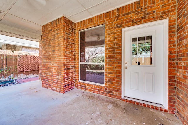 view of exterior entry featuring brick siding