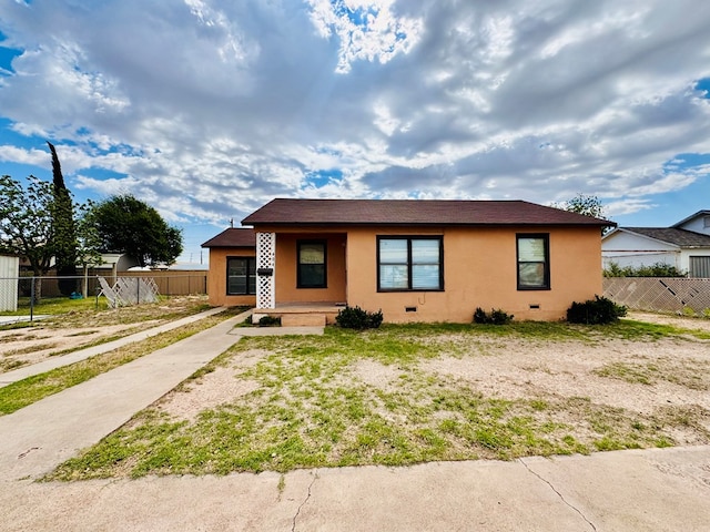 bungalow-style home featuring fence and stucco siding