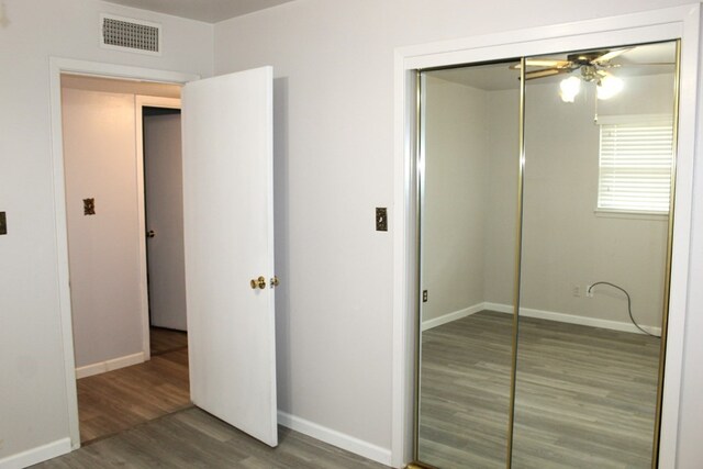 unfurnished bedroom with a closet and dark wood-type flooring