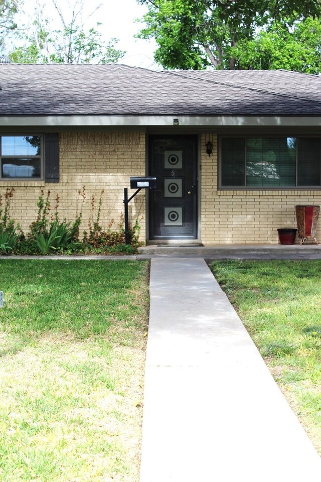 doorway to property with a lawn