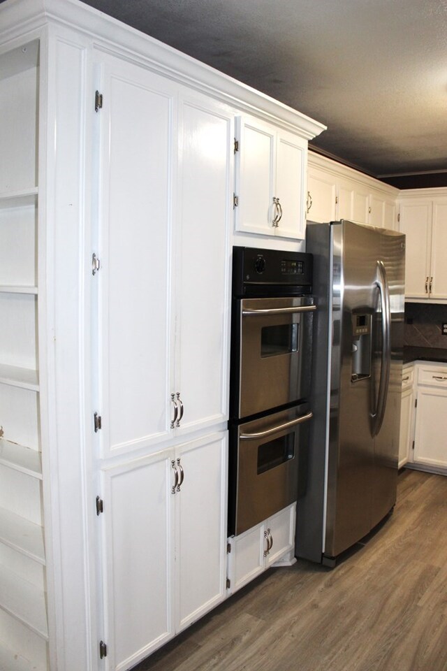 kitchen featuring white cabinetry, stainless steel appliances, and dark wood-type flooring