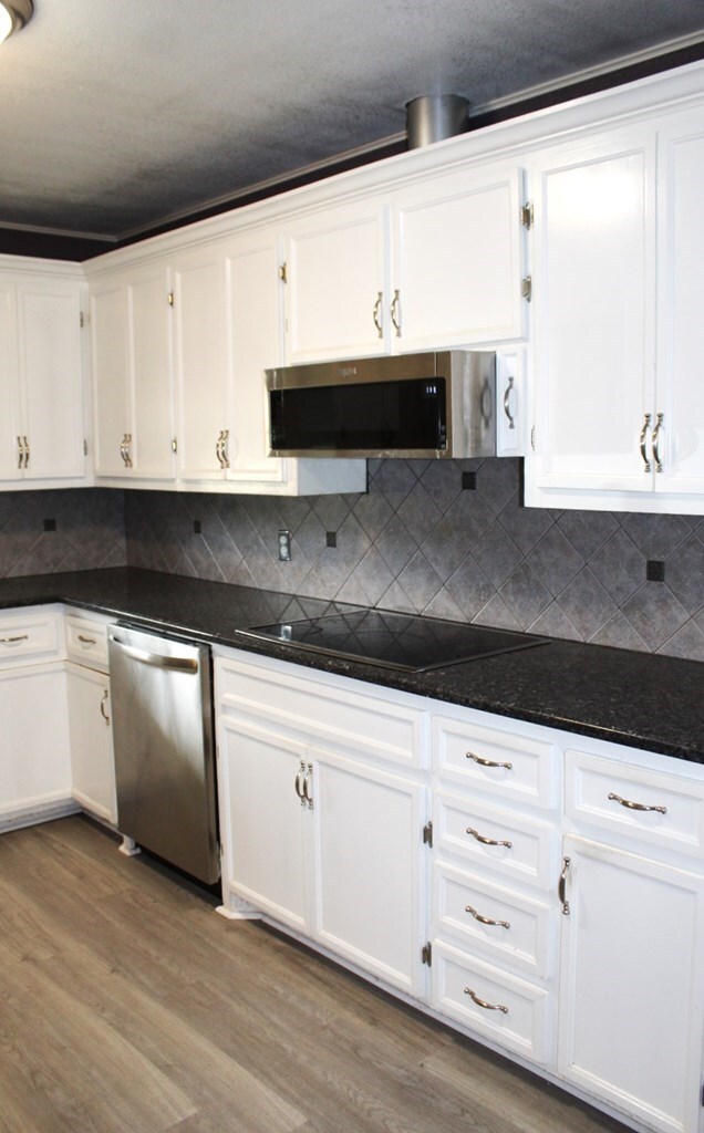 kitchen featuring white cabinetry, light hardwood / wood-style floors, and appliances with stainless steel finishes