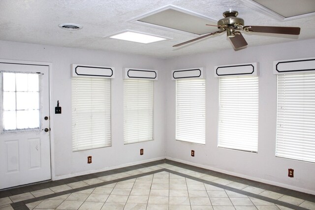 interior space with ceiling fan, light tile patterned floors, and a textured ceiling