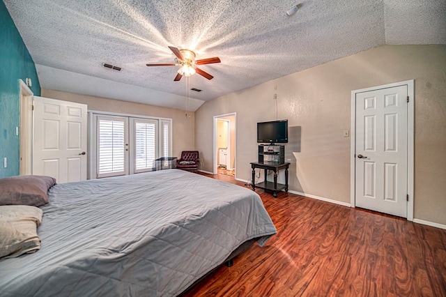 bedroom featuring lofted ceiling, dark hardwood / wood-style flooring, ceiling fan, a textured ceiling, and french doors