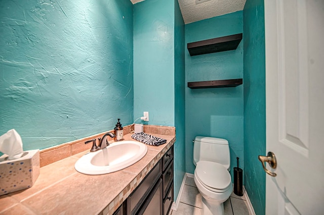 bathroom featuring tile patterned floors, vanity, toilet, and a textured ceiling