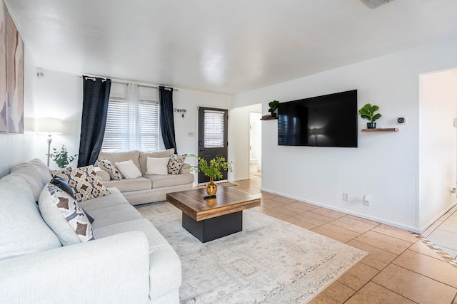 living room with light tile patterned floors, visible vents, and baseboards