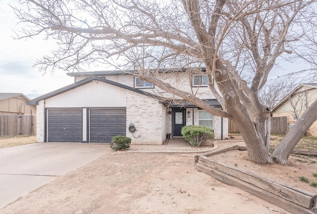 traditional-style home with a garage, fence, and concrete driveway