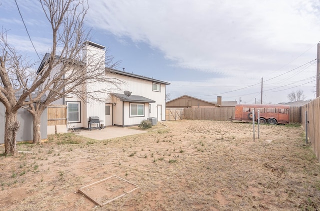 rear view of house with a patio, central AC unit, a chimney, and a fenced backyard