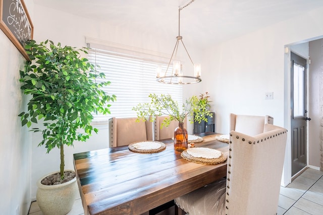 dining area with light tile patterned floors and an inviting chandelier