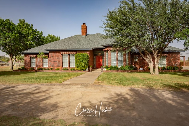 4300 Tumbleweed Trl, Midland, TX 79707 - view of front facade featuring brick siding, a chimney, and a front lawn
