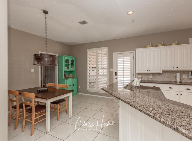 4300 Tumbleweed Trl, Midland, TX 79707 - kitchen with white cabinets, baseboards, decorative backsplash, light tile patterned flooring, and recessed lighting