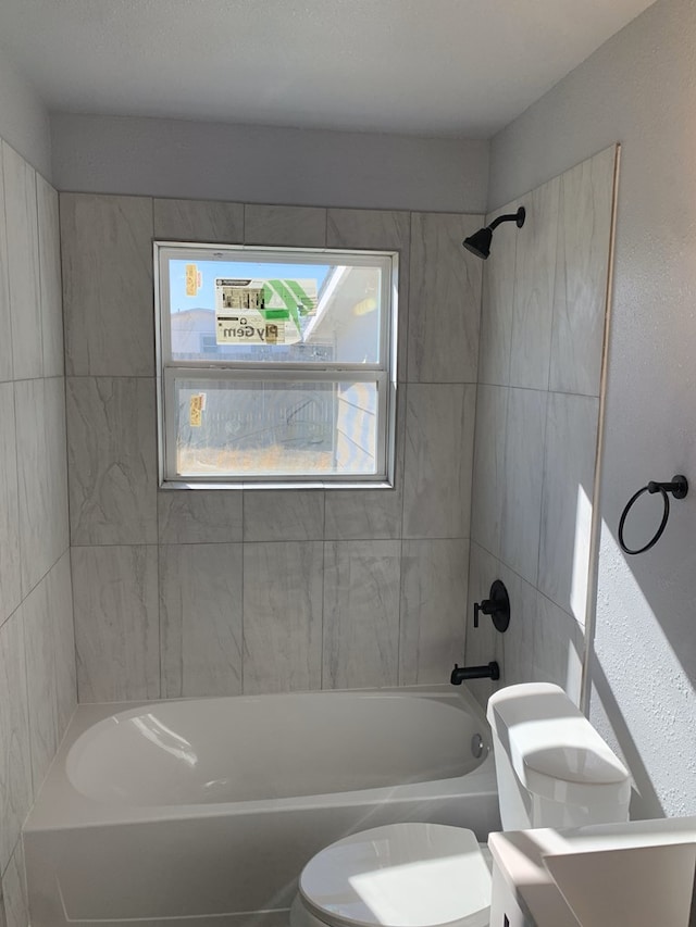 full bathroom featuring vanity, tiled shower / bath combo, and toilet