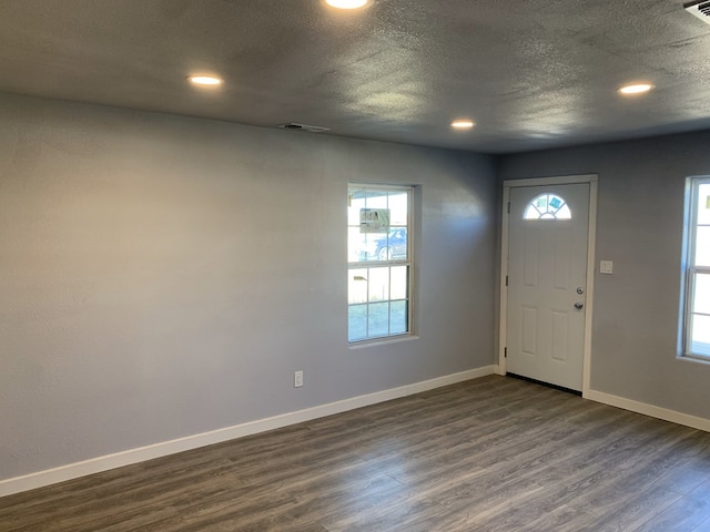 foyer featuring a textured ceiling and dark wood-type flooring