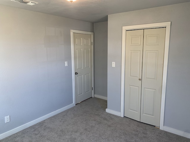 unfurnished bedroom featuring a closet and light colored carpet