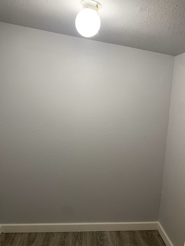 empty room featuring dark hardwood / wood-style flooring and a textured ceiling