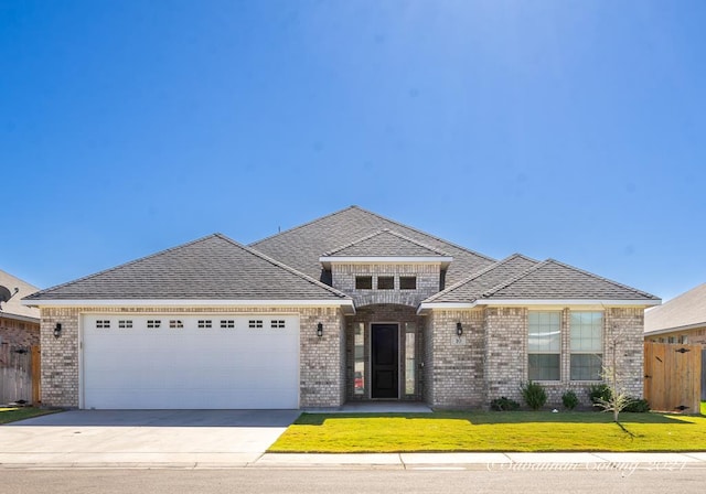 view of front of house with a garage and a front lawn