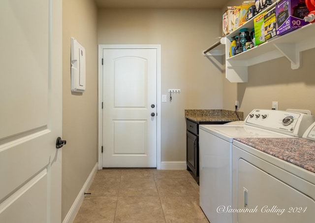 clothes washing area featuring washer and clothes dryer, light tile patterned floors, and cabinets