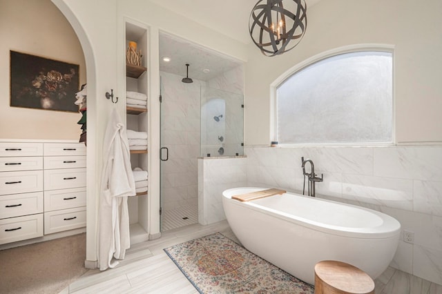 bathroom featuring independent shower and bath and tile walls