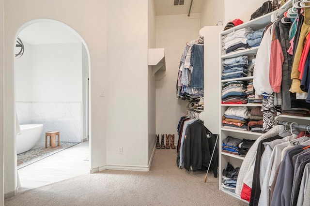 walk in closet featuring light carpet