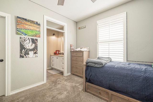 bedroom featuring ceiling fan, connected bathroom, and light carpet