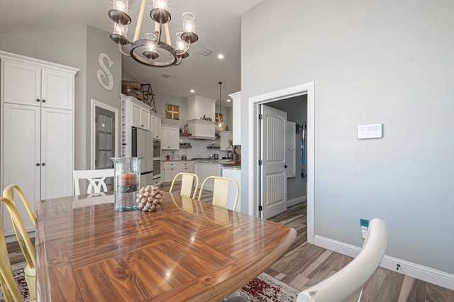 dining space with an inviting chandelier, dark hardwood / wood-style flooring, and high vaulted ceiling