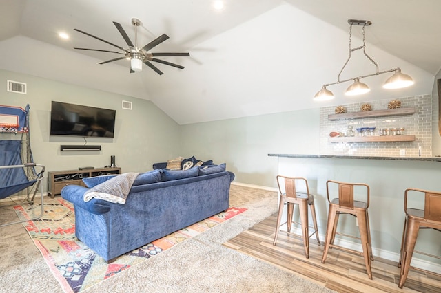 living room featuring lofted ceiling, indoor bar, and ceiling fan