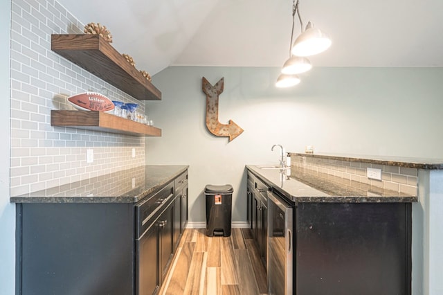 kitchen with vaulted ceiling, decorative light fixtures, tasteful backsplash, sink, and wine cooler