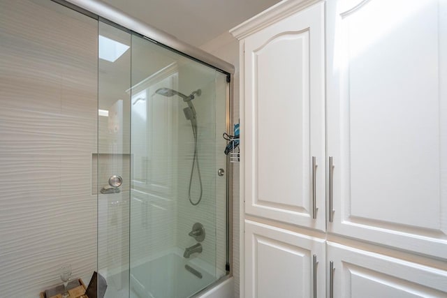 bathroom with shower / bath combination with glass door