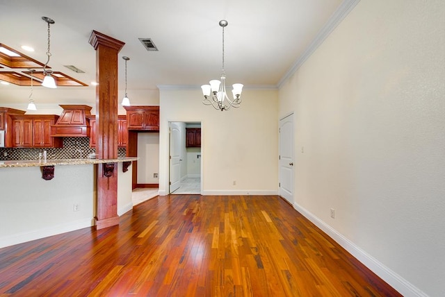 kitchen featuring tasteful backsplash, visible vents, a breakfast bar, dark wood-type flooring, and crown molding