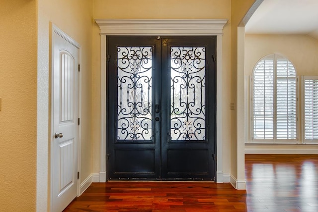 entryway with baseboards, wood finished floors, and french doors