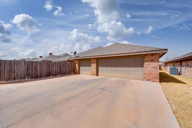 view of home's exterior featuring an outbuilding, brick siding, fence, and central air condition unit