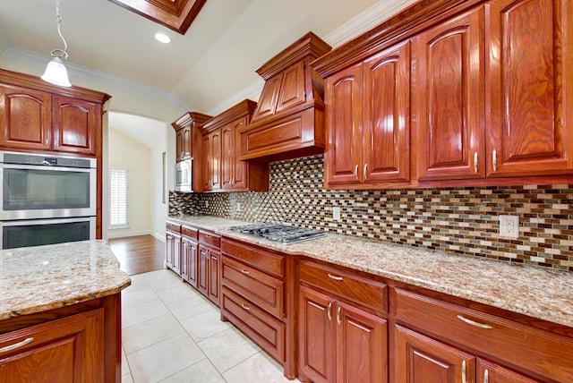 kitchen featuring arched walkways, light stone counters, stainless steel appliances, ornamental molding, and tasteful backsplash