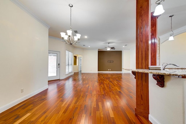 unfurnished living room with baseboards, visible vents, ornamental molding, hardwood / wood-style floors, and ceiling fan with notable chandelier