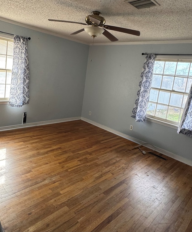 unfurnished room with crown molding, a wealth of natural light, dark hardwood / wood-style floors, and a textured ceiling