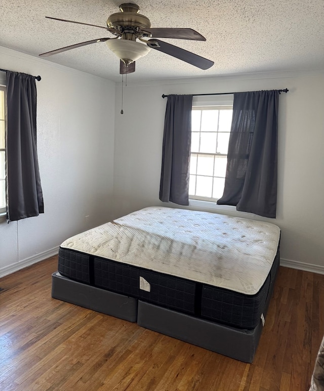 bedroom featuring ceiling fan, dark hardwood / wood-style floors, and a textured ceiling