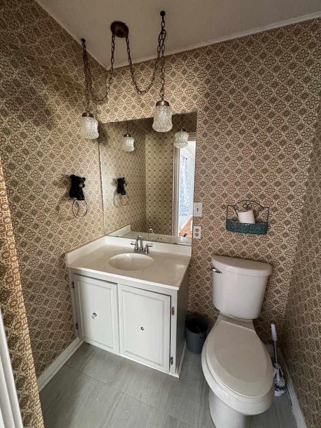 bathroom featuring vanity, ornamental molding, and toilet