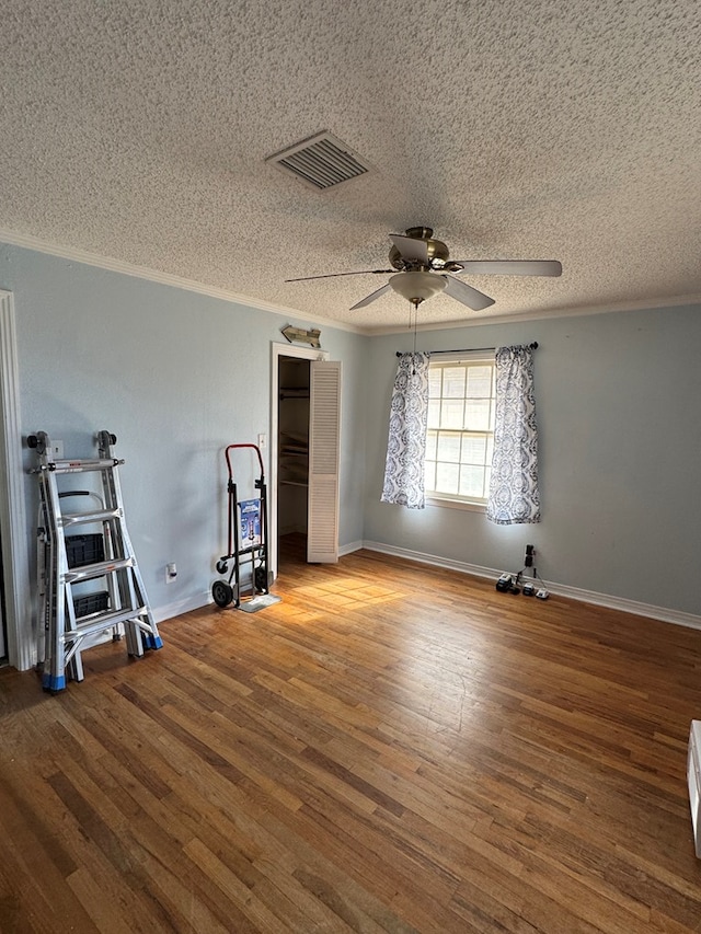 unfurnished bedroom with ornamental molding, hardwood / wood-style floors, and a textured ceiling