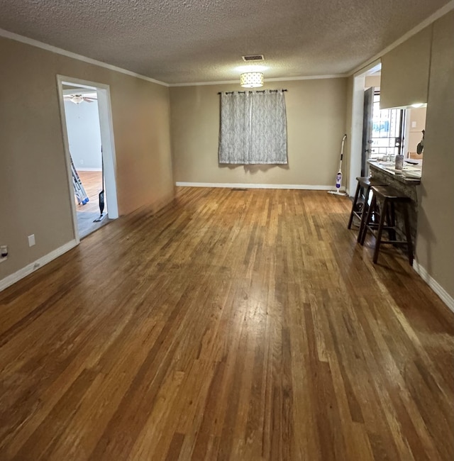 interior space with ornamental molding, hardwood / wood-style floors, and a textured ceiling