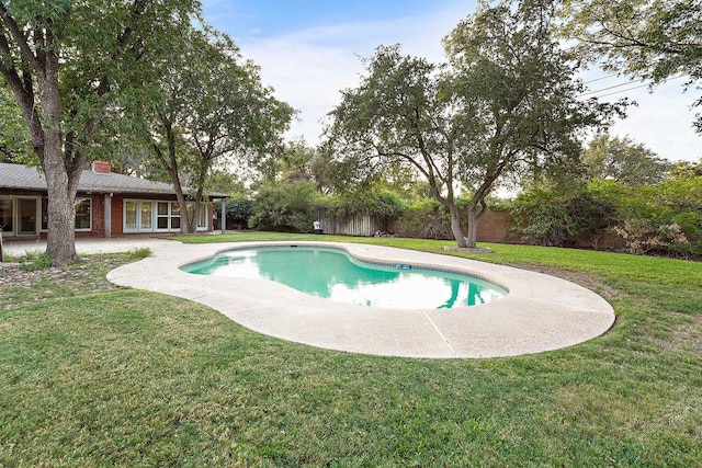 view of pool featuring a lawn