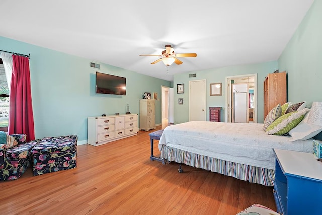 bedroom featuring ceiling fan, ensuite bathroom, and light wood-type flooring