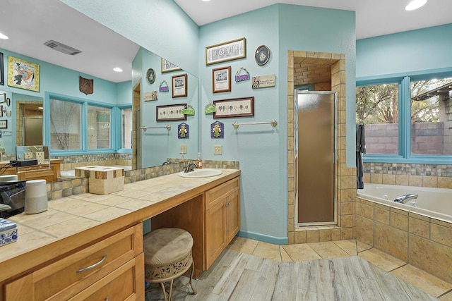 bathroom with vanity, wood-type flooring, and shower with separate bathtub