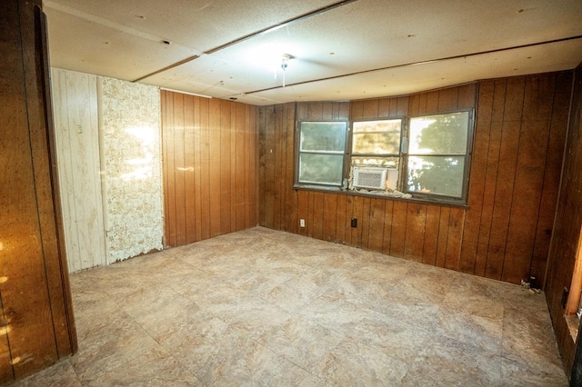 spare room featuring cooling unit and wooden walls