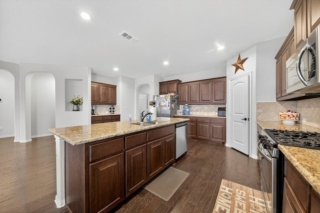 5001 Shadybrook Rd, Midland, TX 79705 - kitchen featuring arched walkways, appliances with stainless steel finishes, a sink, dark wood-type flooring, and recessed lighting
