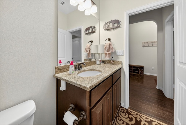 5001 Shadybrook Rd, Midland, TX 79705 - half bath with vanity, hardwood / wood-style flooring, toilet, and baseboards