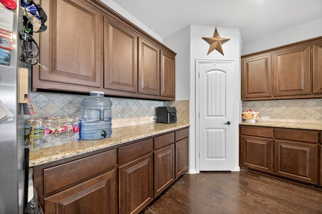 5001 Shadybrook Rd, Midland, TX 79705 - kitchen with freestanding refrigerator, dark wood-style floors, decorative backsplash, and light stone countertops