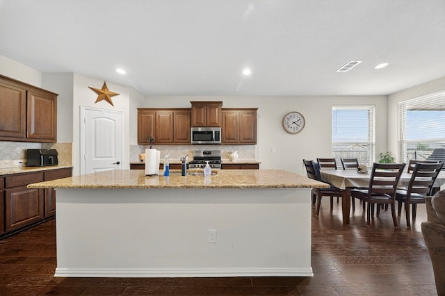 5001 Shadybrook Rd, Midland, TX 79705 - kitchen with stainless steel appliances, a center island with sink, light stone counters, backsplash, and recessed lighting