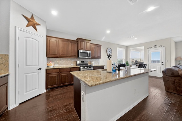 5001 Shadybrook Rd, Midland, TX 79705 - kitchen featuring appliances with stainless steel finishes, dark wood-style flooring, a sink, open floor plan, and decorative backsplash