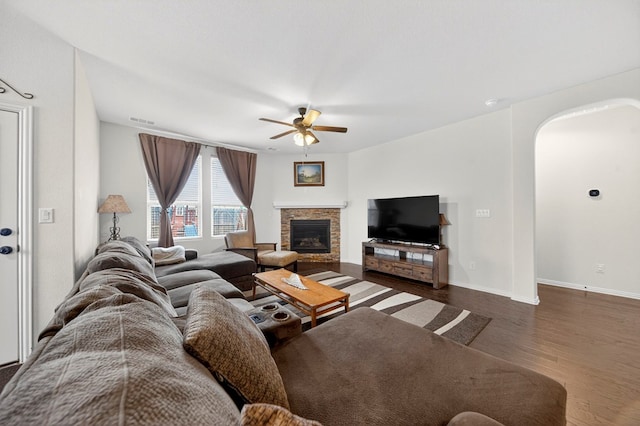 5001 Shadybrook Rd, Midland, TX 79705 - living area with ceiling fan, wood finished floors, a stone fireplace, arched walkways, and baseboards