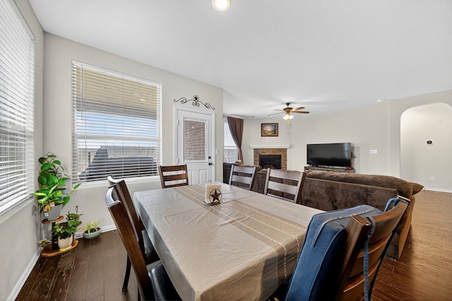 5001 Shadybrook Rd, Midland, TX 79705 - dining room with arched walkways, a fireplace, baseboards, and a ceiling fan