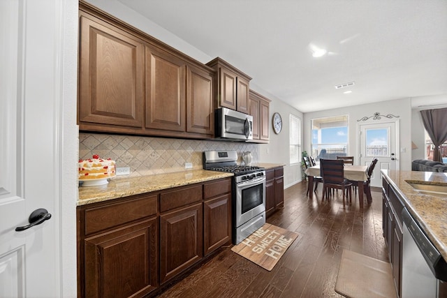 5001 Shadybrook Rd, Midland, TX 79705 - kitchen featuring appliances with stainless steel finishes, dark wood finished floors, backsplash, light stone counters, and recessed lighting